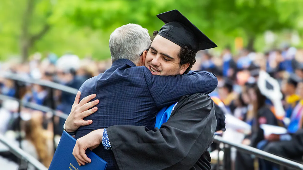 A graduate hugging the parent