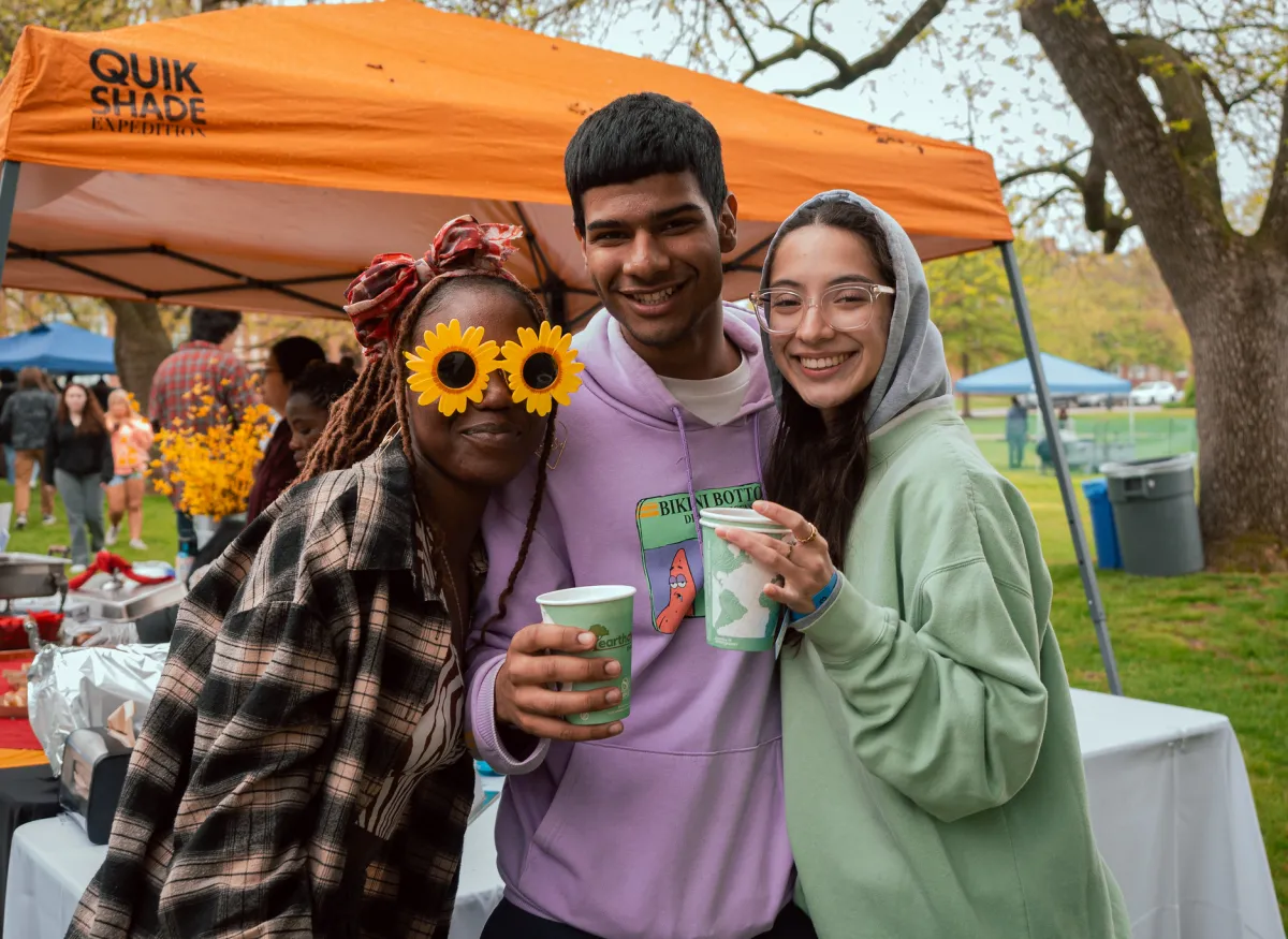 3 students posing at International Food Fest with drinks in hand