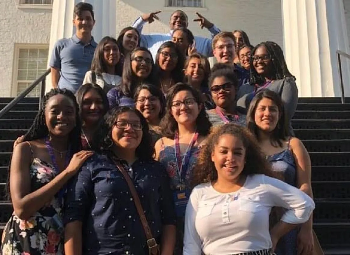 A group of people pose for a picture by the stairs