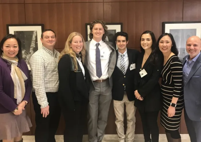 A group of people posing indoors in business attire