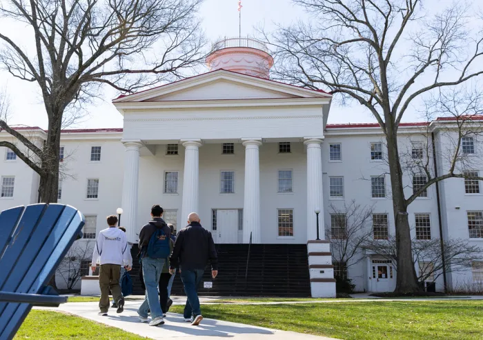 A group of people walking towards the Penn Hall
