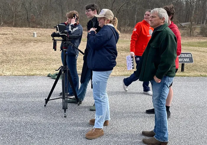 A small group filming outdoors