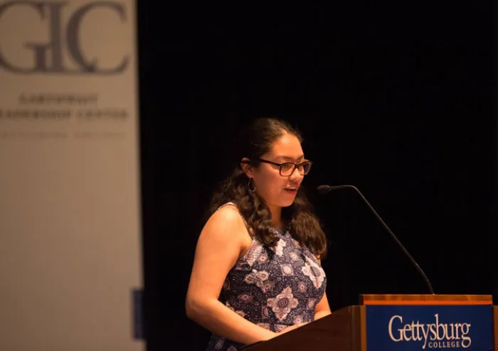 A woman speaks at a podium.