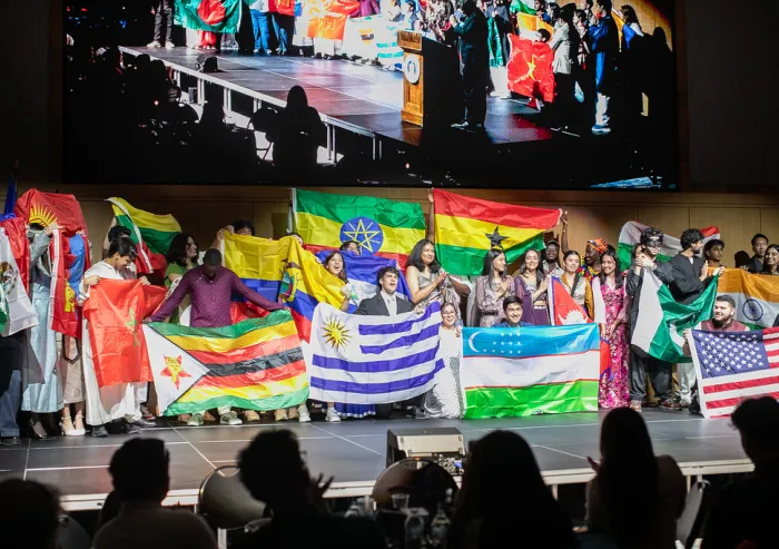 A group of international students holding their flags