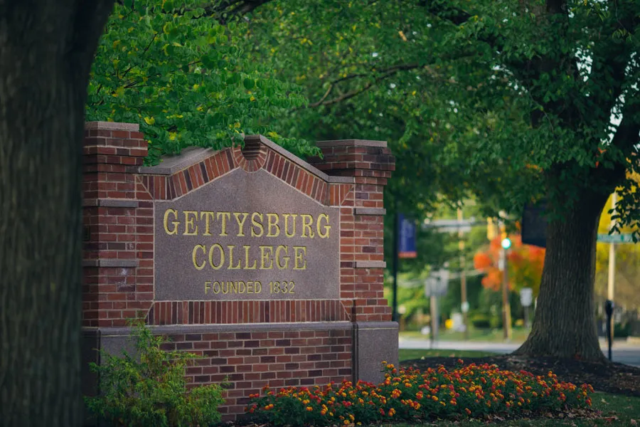 Gettysburg College campus sign with brillian foliage behind it