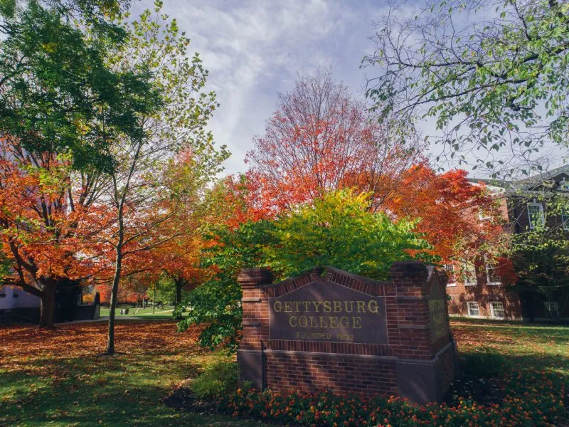 Gettysburg College campus sign with brillian foliage behind it