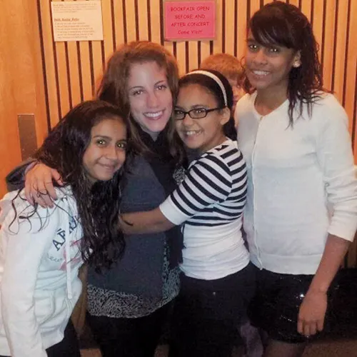 students pose with young local students