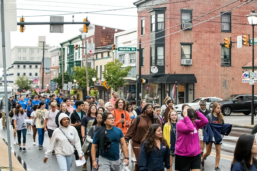 large group of students walk in streets of Gettysburg together on first year walk
