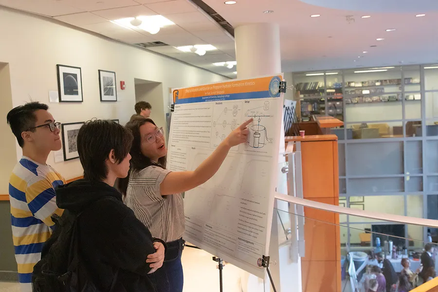 student explains poster at expo for Cross-Disciplinary Science Institute