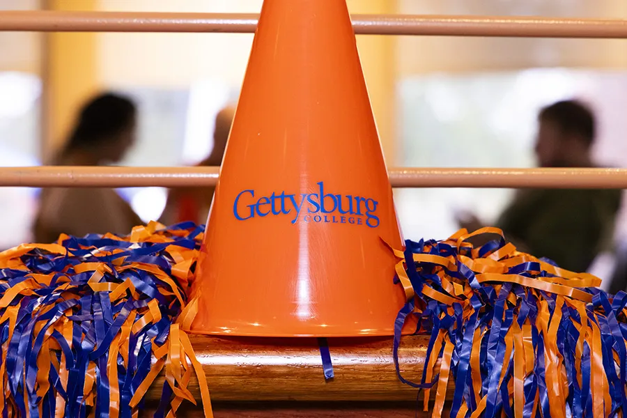 orange and blue pompoms and orange Gettysburg College megaphone