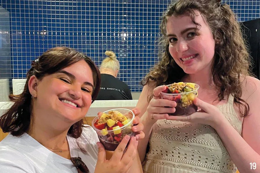 two female students pose with fruit cups