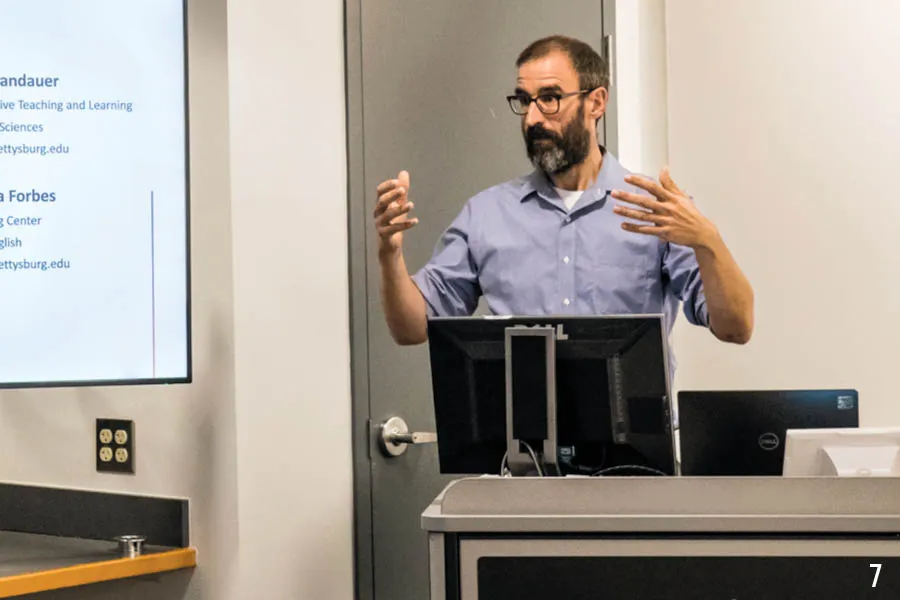 prof gestures from behind podium