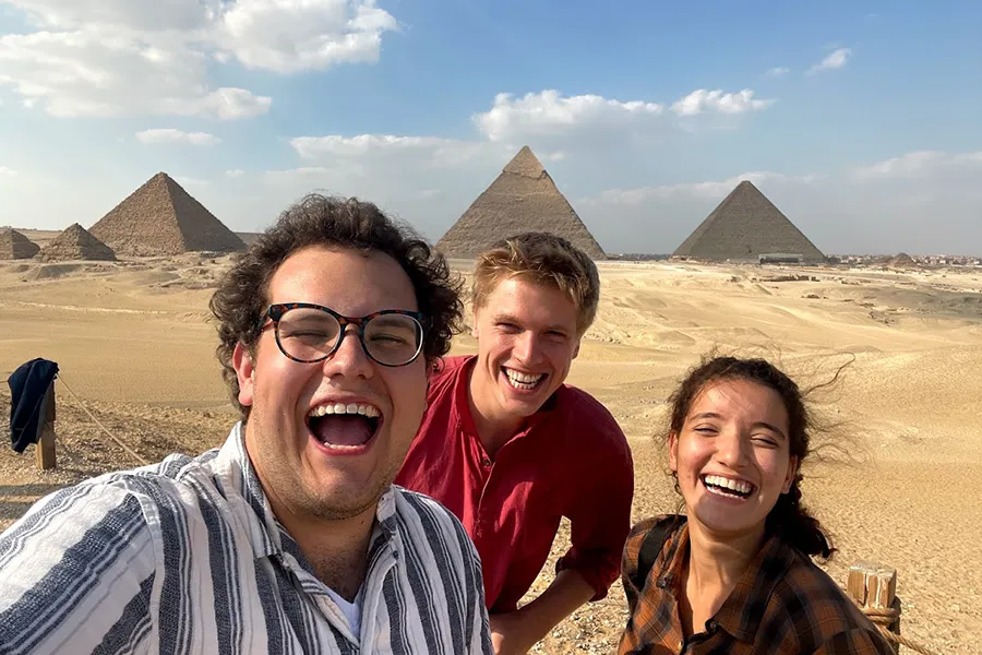 Brandon Neely with two people in front of pyramids