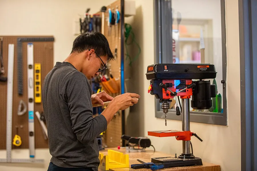 A student adjusts part of a wood component