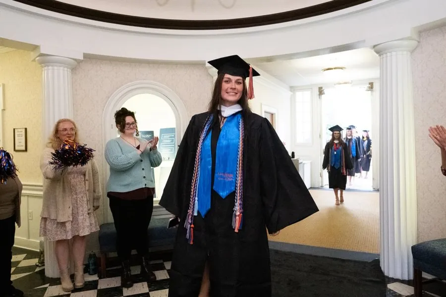 Softball senior Paige Forry walks through Penn Hall after Special Commencement.