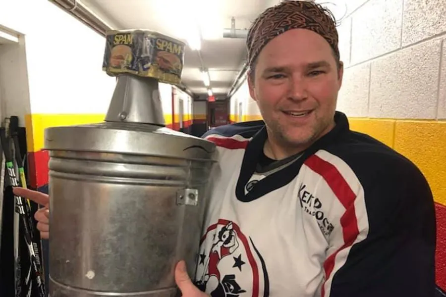 hockey player holds up metal bucket