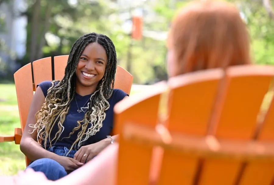 female students sitting on adirondack chairs