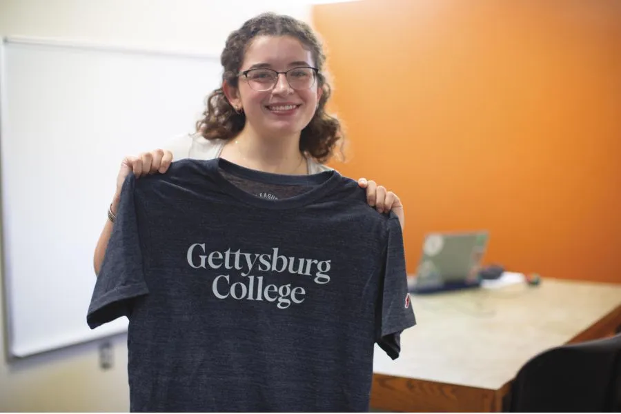 A student holding up the Gettysburg T-shirt