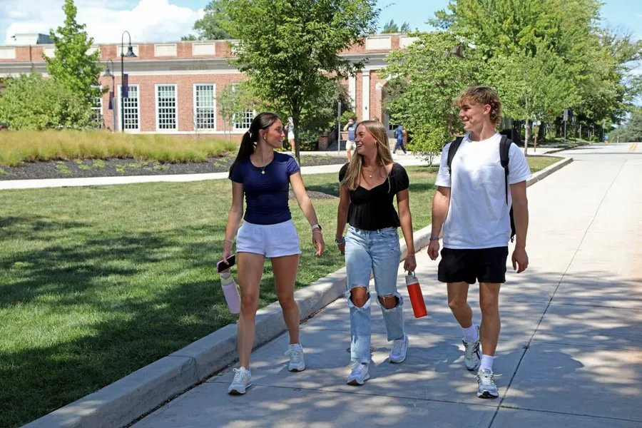 group of students walk across campus together