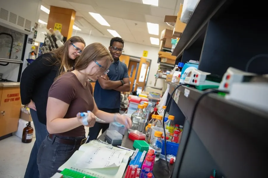 Sarah Marcus ’26 and Rudy Rudatsikira ’27 work with Prof. Kate Buettner in the chemistry lab.