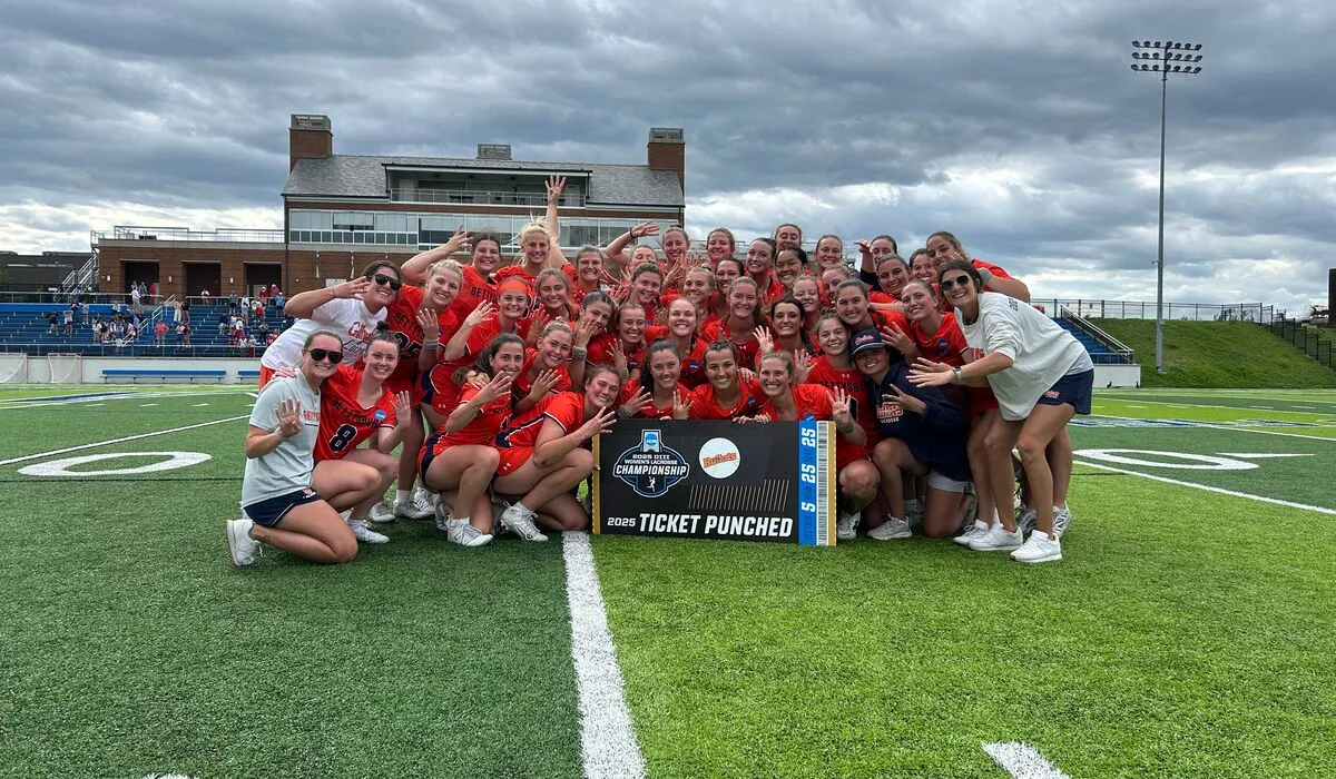 womens lacrosse team posing together on field