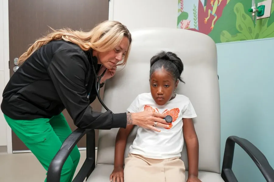 female nursing student performs checkup on child
