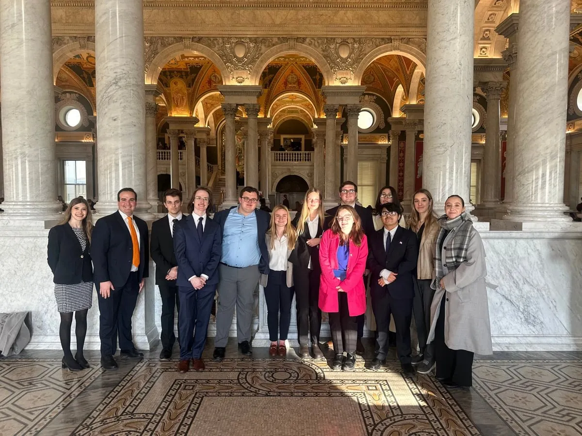 students in professional attire in ornate lobby of building
