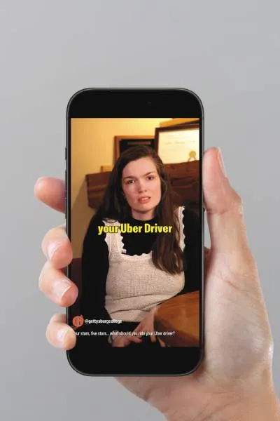 photo of hand holding a phone with a YouTube video displaying about Uber drivers