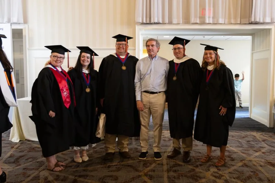 Master's graduates pose for a photo with GLI President and CEO Jim Basker.