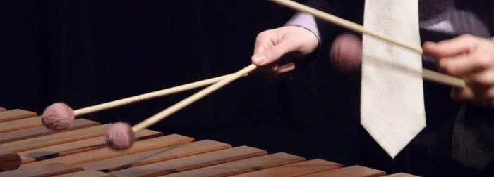 Musician playing a xylophone with mallets.
