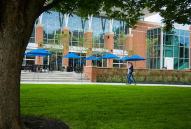 Two students walk along the path ajacent to CUB green.