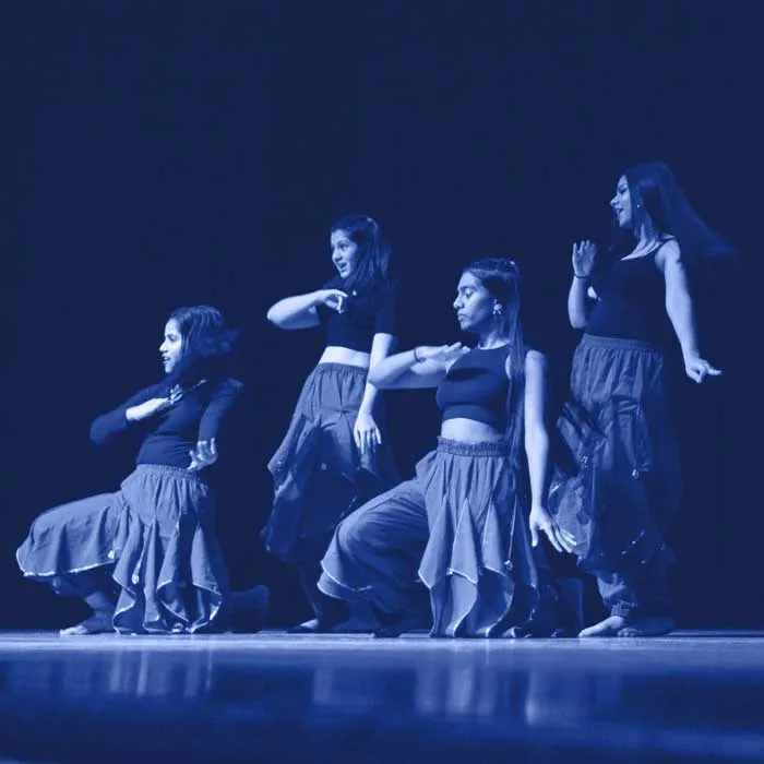 A photo of a group of dancers with a blue filter over it.