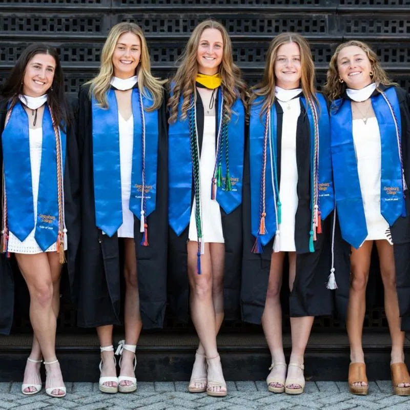 Graduates in blue stoles pose together.