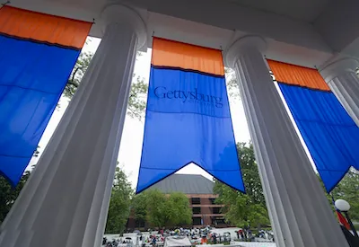 A view from behind the Pennsylvania Hall columns looking out over a crowd.