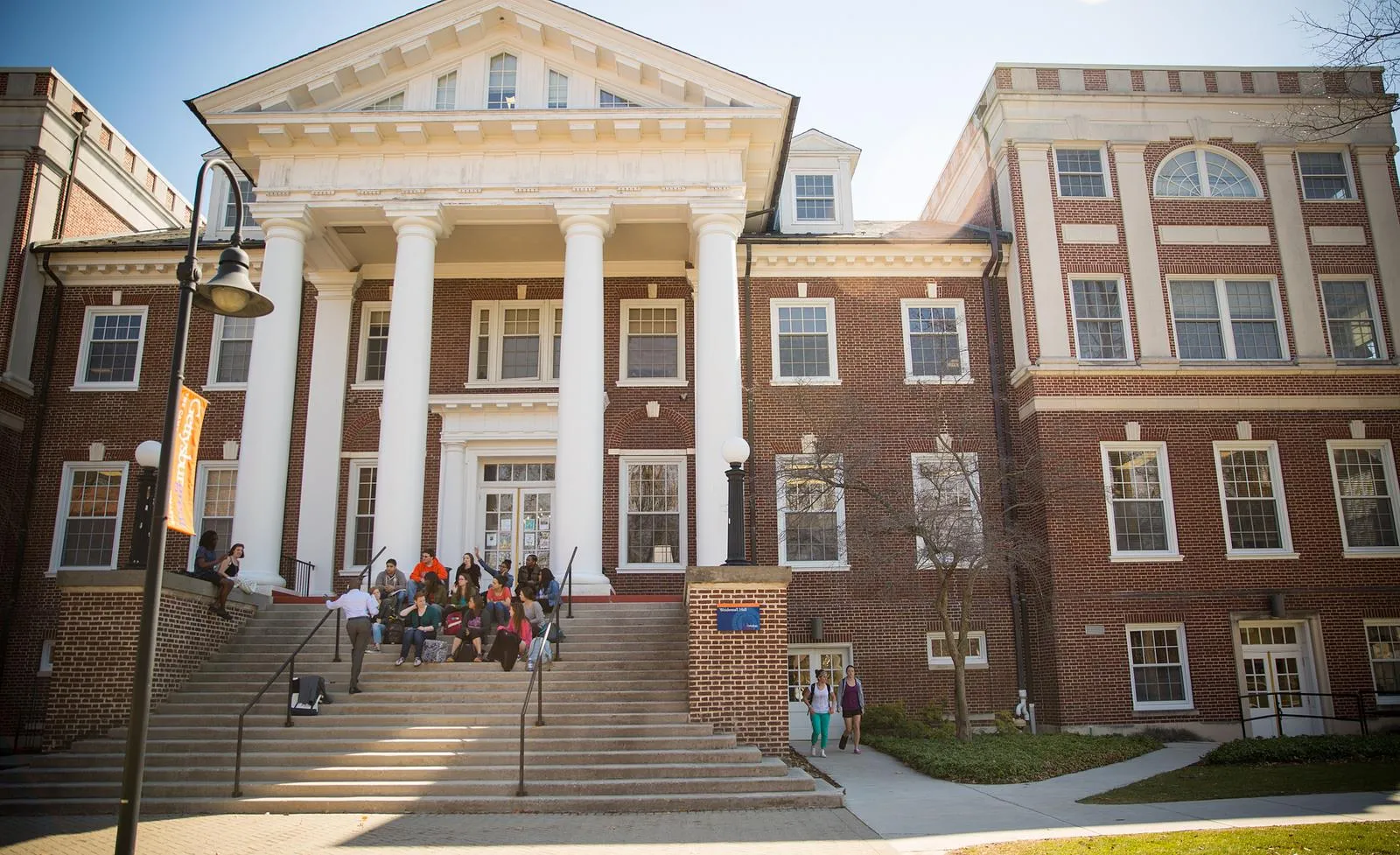 A group of students sit on stairs on campus.