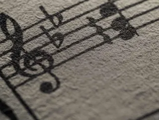 Close-up of handwritten musical notation on textured paper.