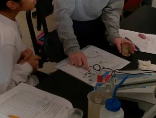 Students collaborating around a table during a hands-on activity.