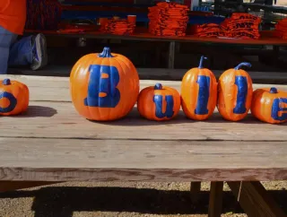 Painted pumpkins spelling “Go Bullets” on a picnic table.