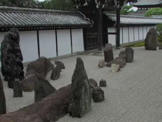 A courtyard featuring a row of dark stone sculptures