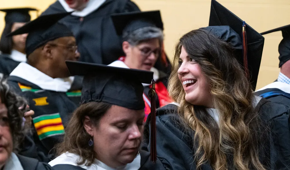 grads laugh together in audience