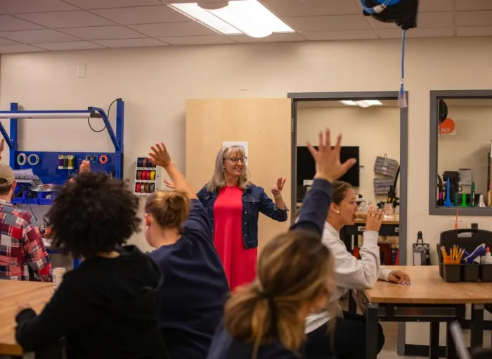 Prof engaging with class in innovation lab