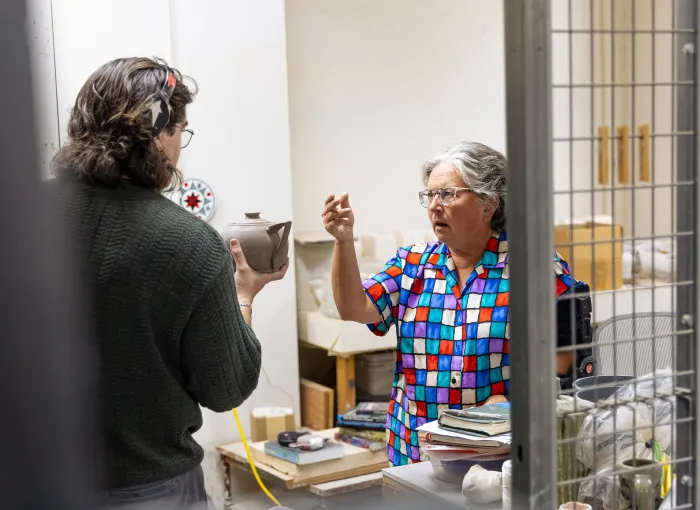 Art faculty and student talk in ceramics studio