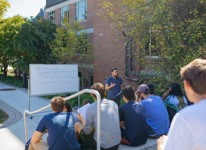 Students attend class outside.