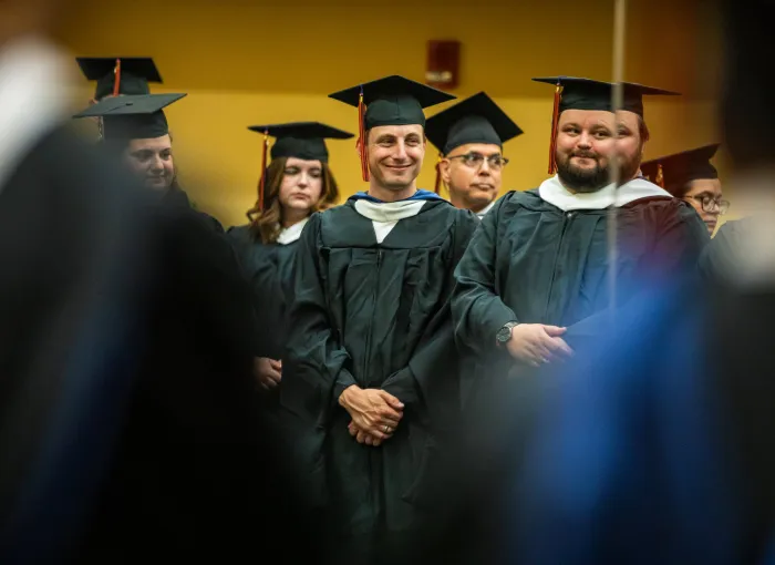 grads smile together in mirror