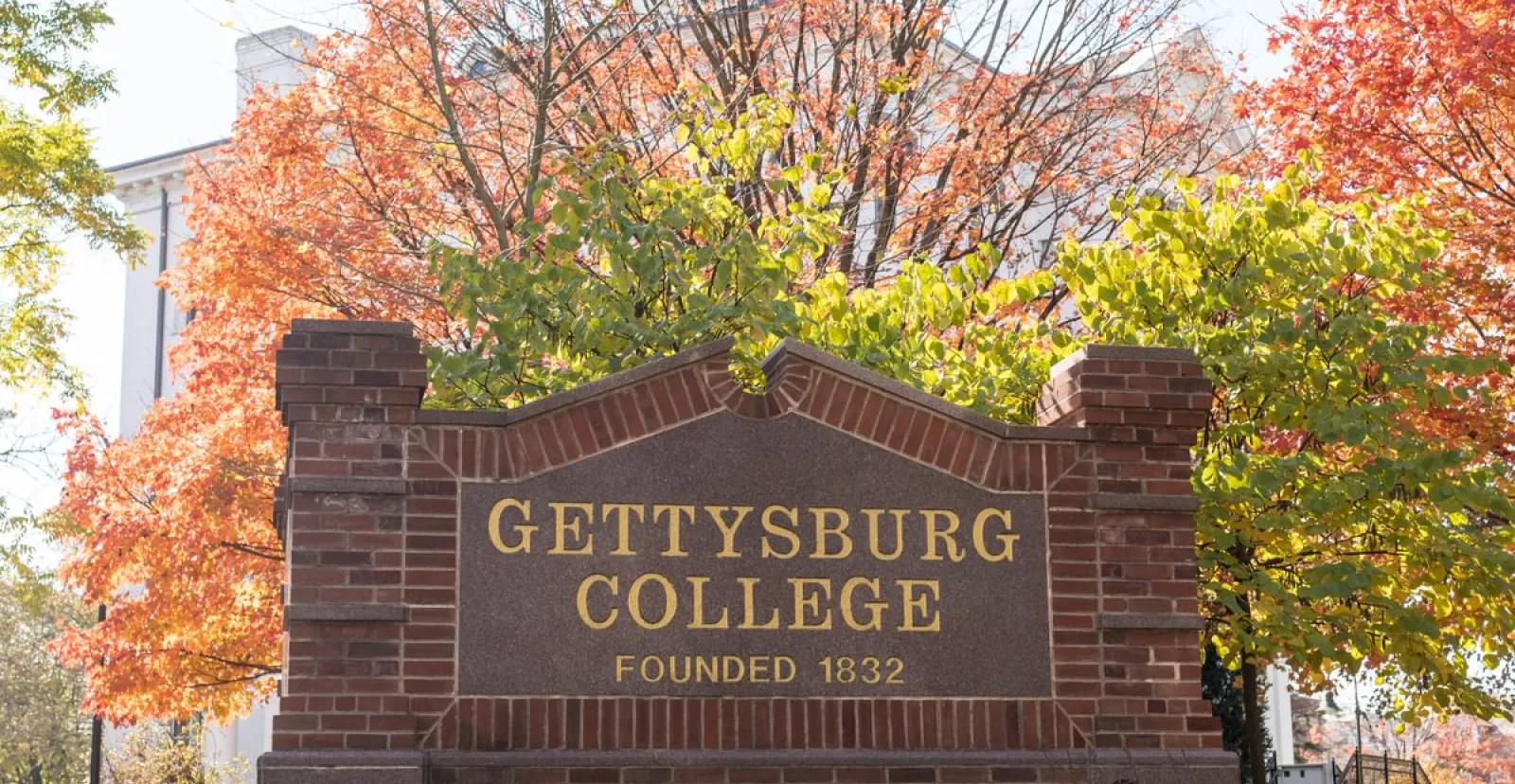 Gettysburg College sign on Washington Street with fall foliage in background