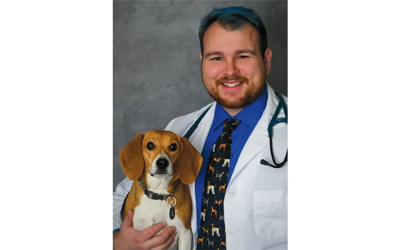 A photo of Dr. Mike Karchner ’19 holding his beagle, Hazel