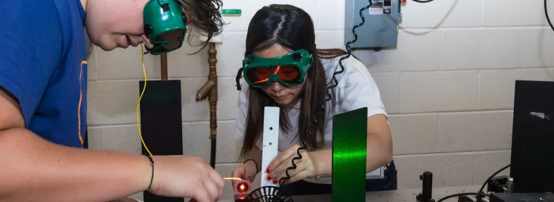 students with goggles work in physics lab