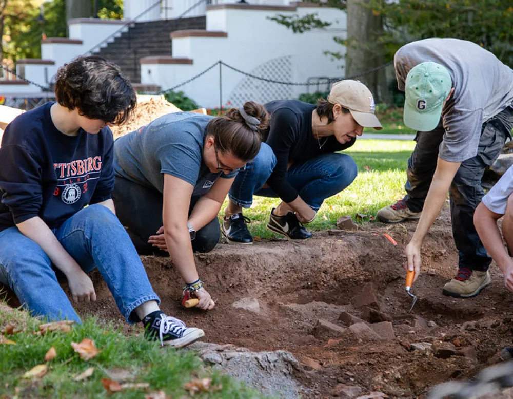 group of students and a prof at a dig